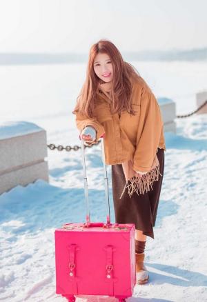 雪国世界里拖着行李箱的美女图片