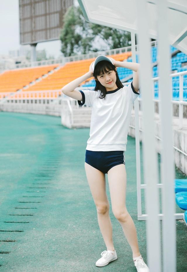 体育场上的运动服性感女孩靠在栏杆上歇息