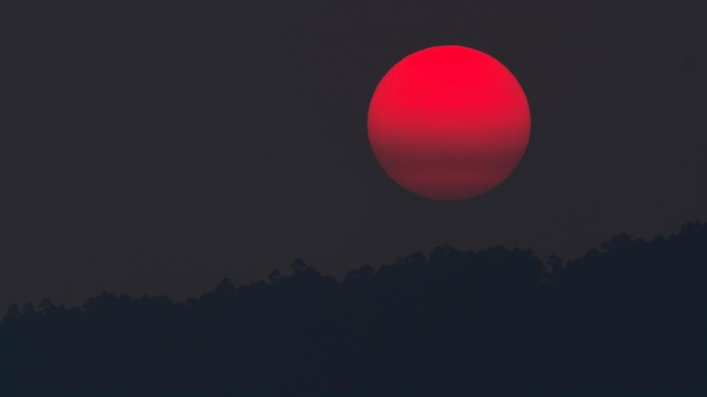 日落时山峰上红色的月亮