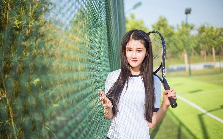 阳光下运动服套装美少女拿网球拍户外写真