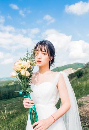 高原上森系少女穿白色婚纱拍唯美写真